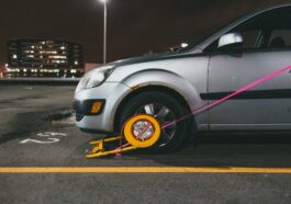 a silver car locked with a wheel clamp