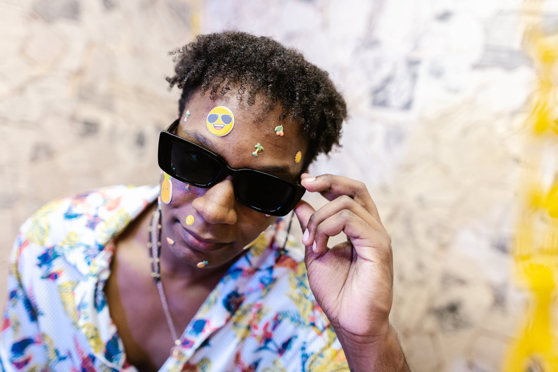 close up shot of a curly haired man wearing black sunglasses