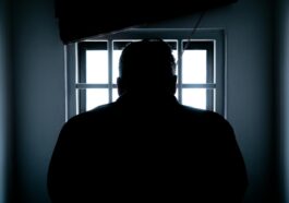 rear view of a silhouette man in window prison