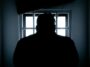 rear view of a silhouette man in window prison