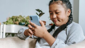 concentrated asian girl looking at smartphone